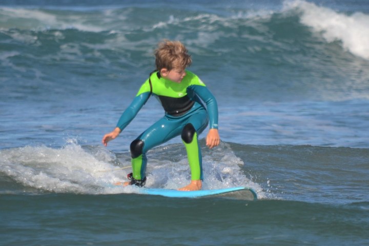 a young man riding a wave on a surfboard in the ocean